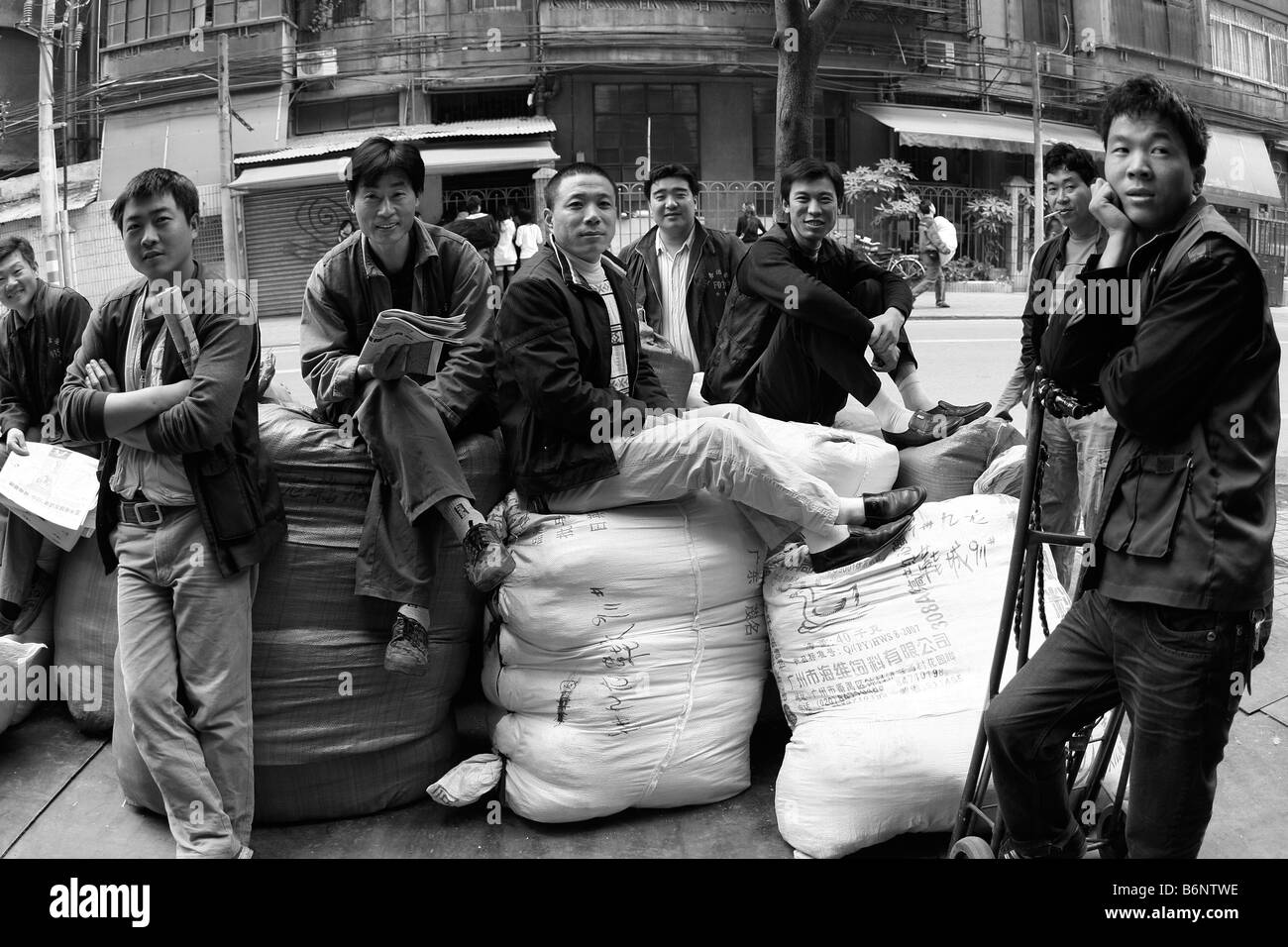 Questi lavoratori di troppo ma un sorriso per la telecamera... persone come loro che sono a maggior rischio immediato se si arriva presto tutti Foto Stock