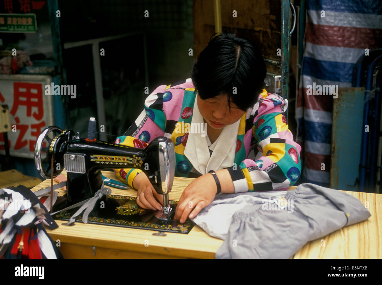 Donna cinese la cucitura con la macchina da cucire, sarta al lavoro della città di Pechino, la Municipalità di Pechino, Cina Foto Stock