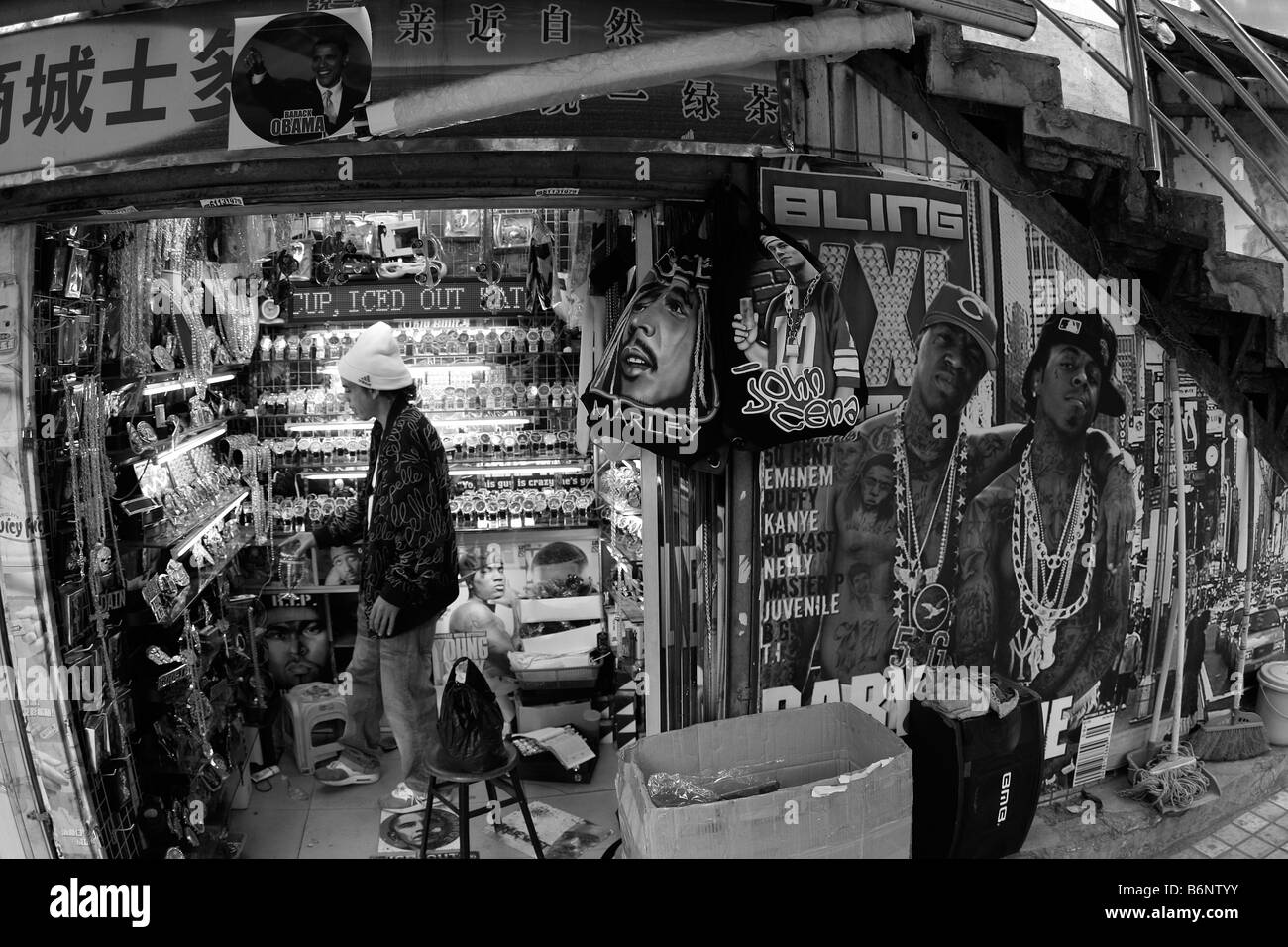 I lavoratori passano attraverso uno stretto vicolo collegamento sul loro modo di lavorare al di sotto di un negozio chiuso segno che è specializzato nell'esportazione a c Foto Stock