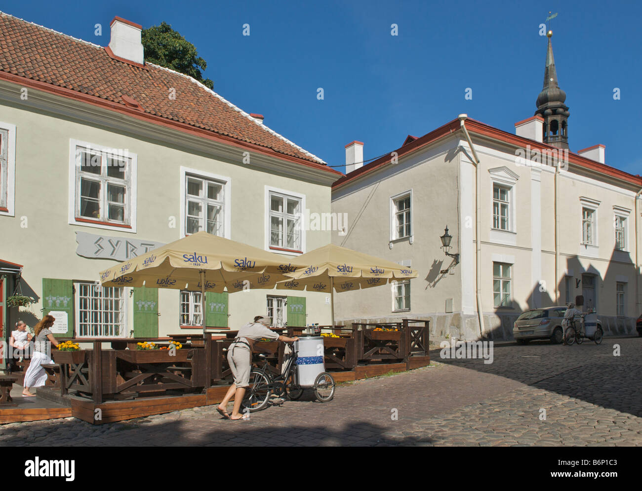 Fornitore di bevande spingendo il triciclo fino acciottolata strada pietra Piiskopi Toompea Hill Tallinn Estonia Foto Stock