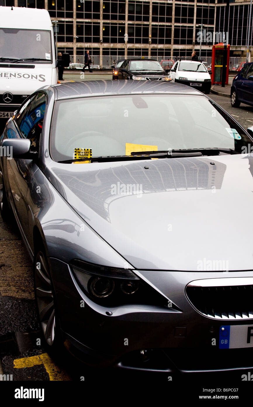 Auto con i biglietti per il parcheggio, non su linee di colore giallo Foto Stock