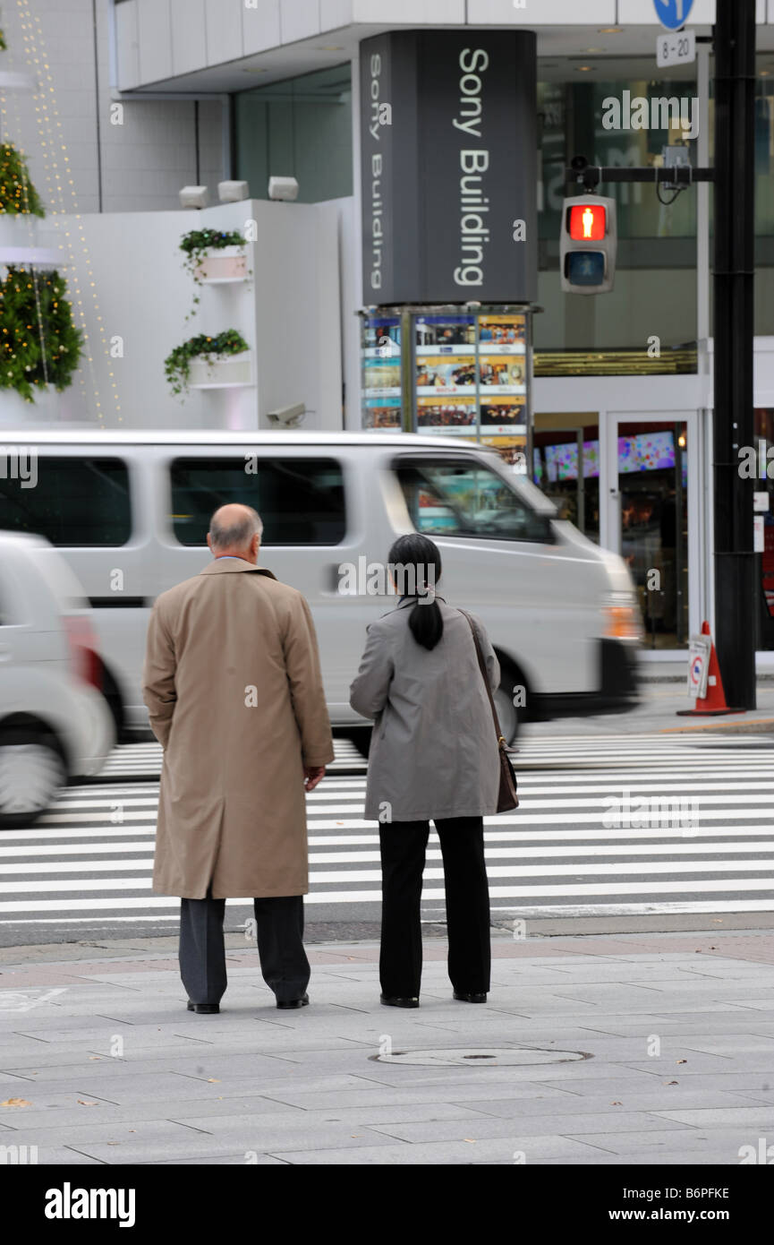 Un paio di attendere presso la traversata in Ginza Tokyo di fronte al Sony building di Ginza, Tokyo Foto Stock