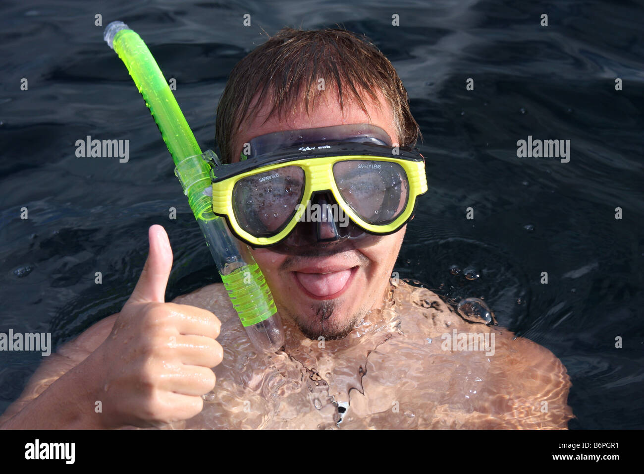 Snorkeller con maschera e snorkel facendo facce buffe e il pollice in su gesto Foto Stock