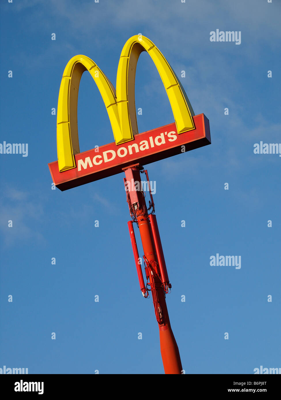 Grande Mc Donalds firmare la pole con il blu del cielo e la rete cellulare antenne Foto Stock