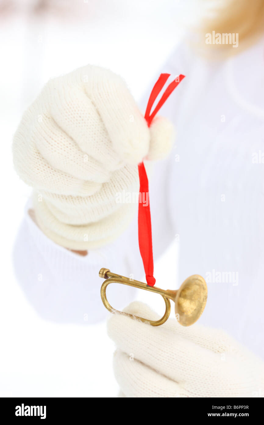 Le mani con guanti invernali azienda Golden tromba albero di Natale ornamento Foto Stock