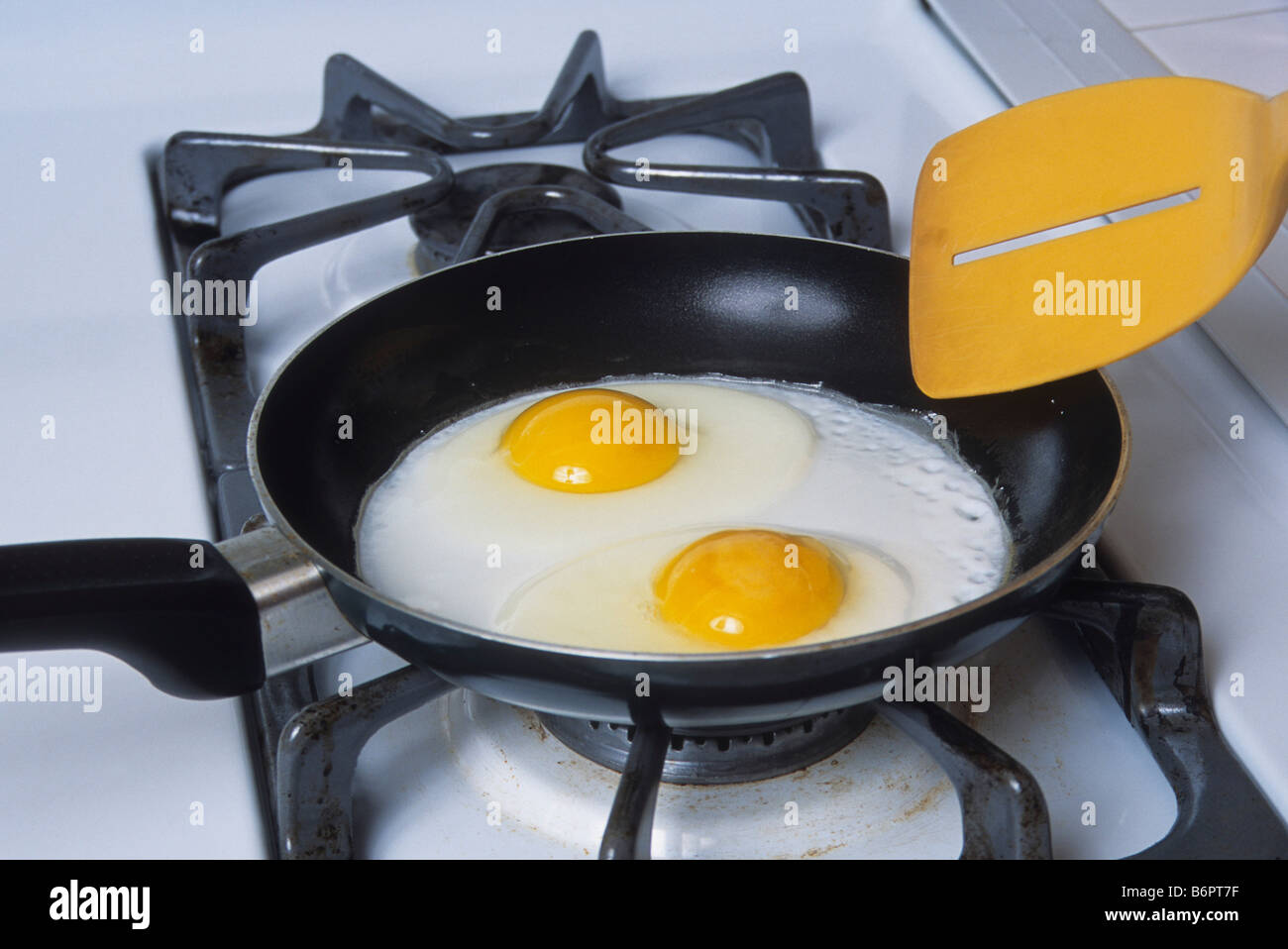Due uova fry sunny side fino in padella sul fornello a gas. Foto Stock