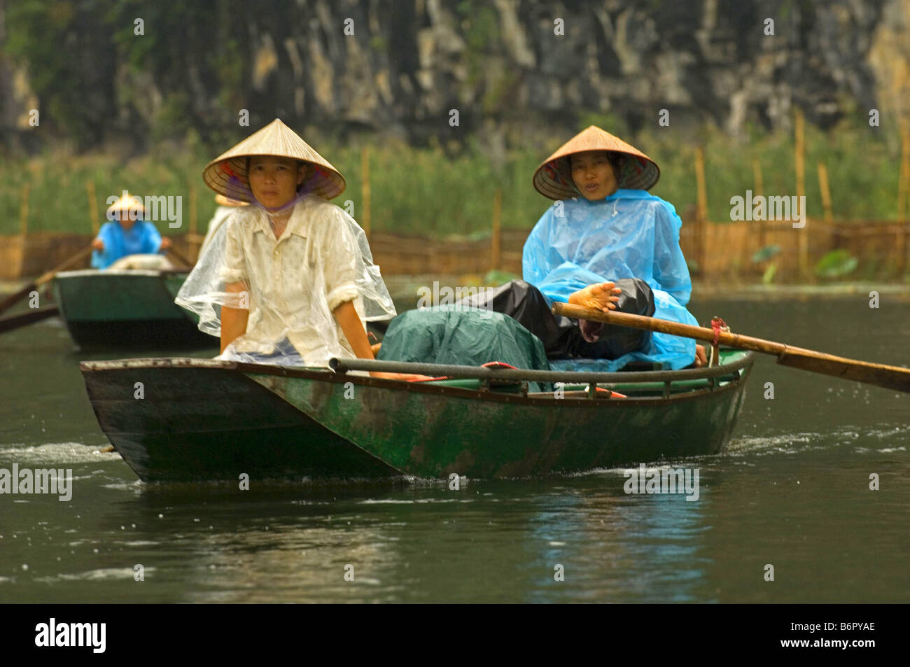 Persone con piccole imbarcazioni con raw, Halong Bay, Vietnam Foto Stock