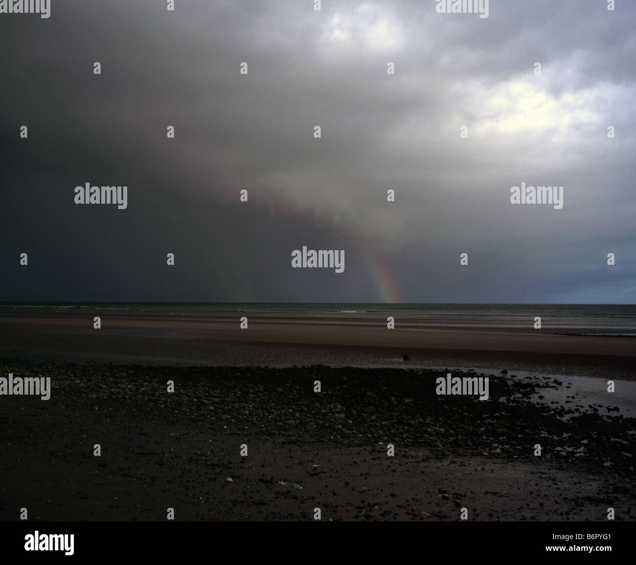 Tempesta passando attraverso la spiaggia di Newcastle contea di Down su una sera d'autunno con rainbow Irlanda Foto Stock