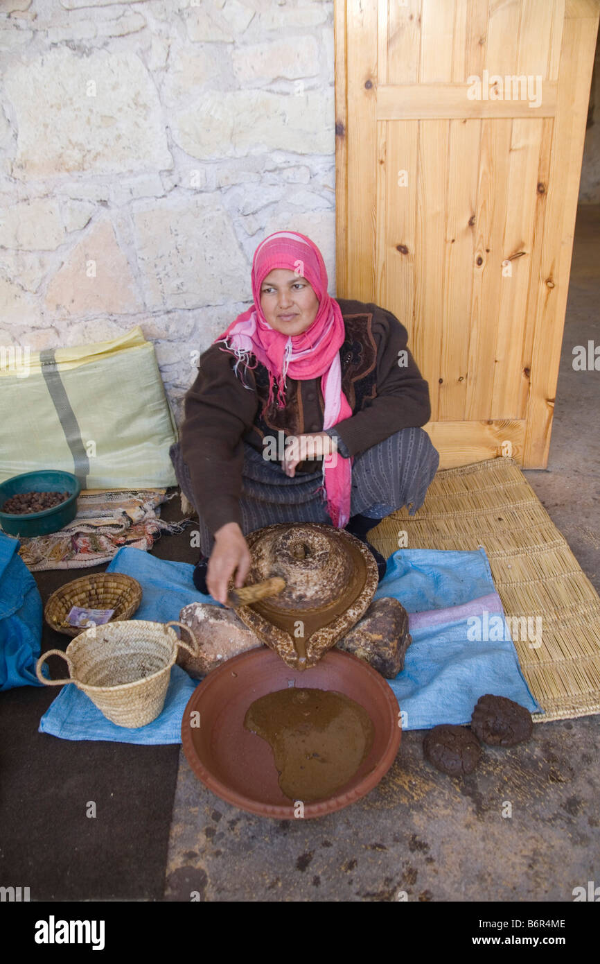 Il Marocco in Nord Africa dicembre donna marocchina macinare la mandorla noccioli di Argan alberi da frutto per produrre pasta spessa femmina co-operativa Foto Stock