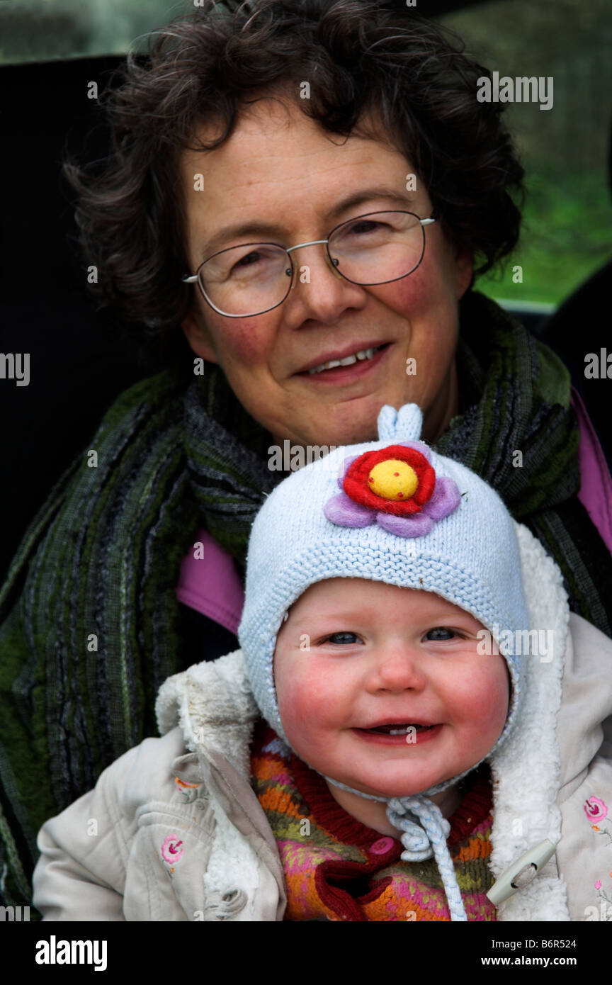 Donna di mezza età e 11 mesi di età infantile giovani raggruppati per basse temperature Foto Stock