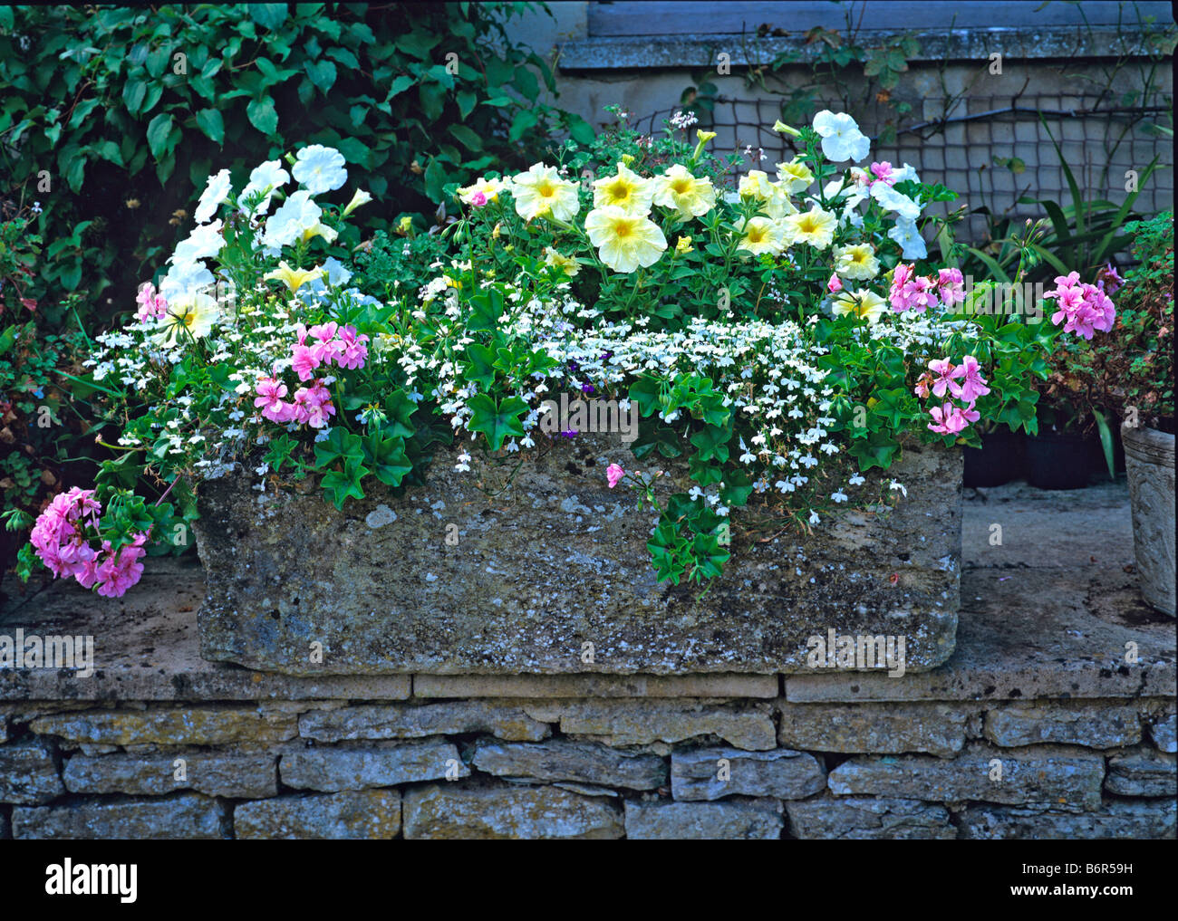 Biancheria da letto a pastello in un trogolo di pietra Foto Stock