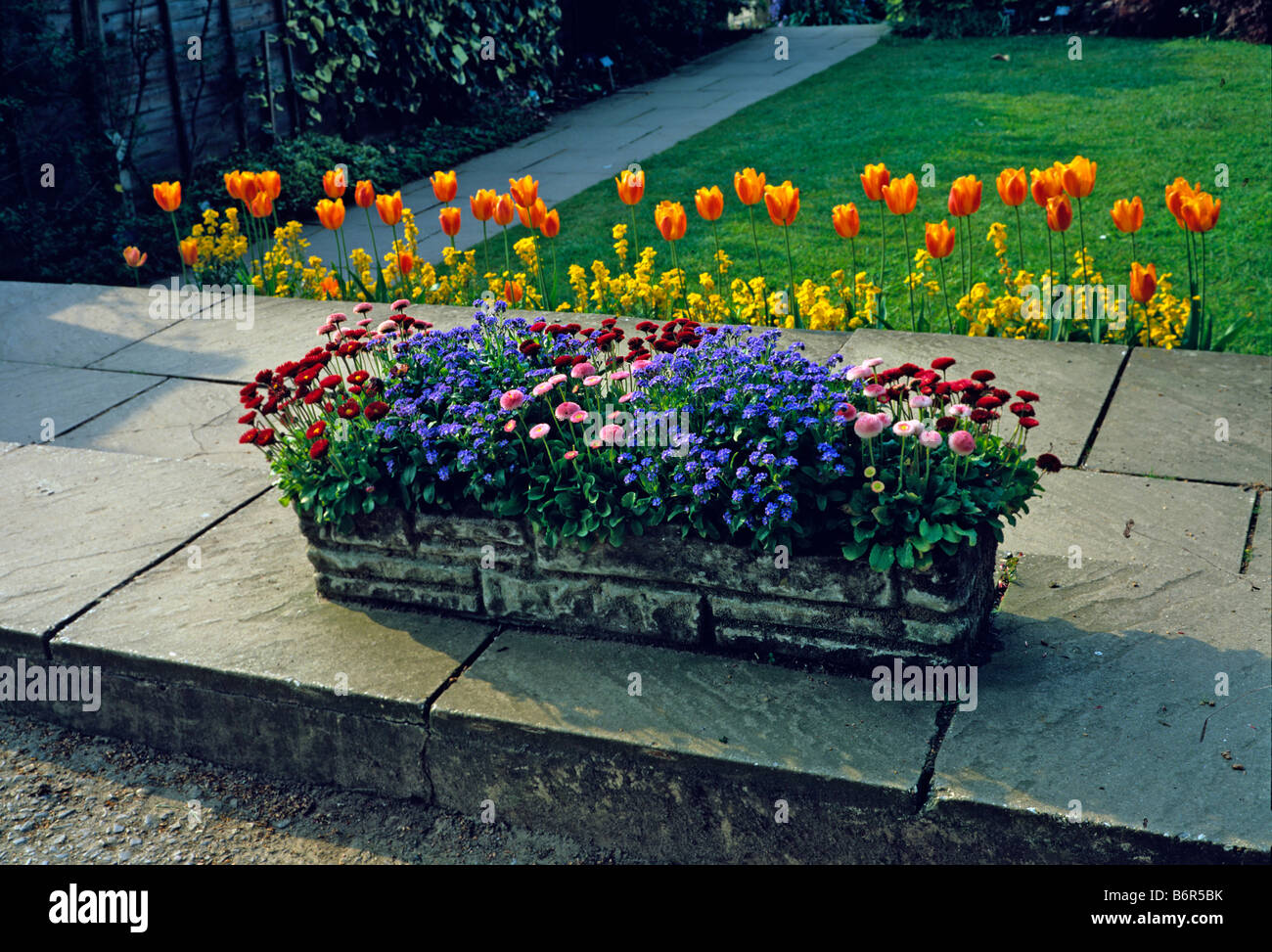 Biancheria da letto a molla in un trogolo di pietra su una terrazza giardino Foto Stock