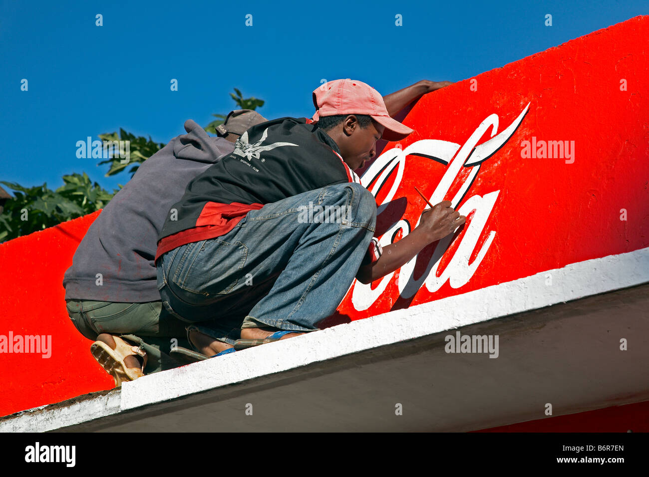 Coca Cola logotipo essendo dipinta sulla facciata in Antsirabe Antananarivo Madagascar Coca Cola Schriftzug wird auf Fassade gemalt Foto Stock