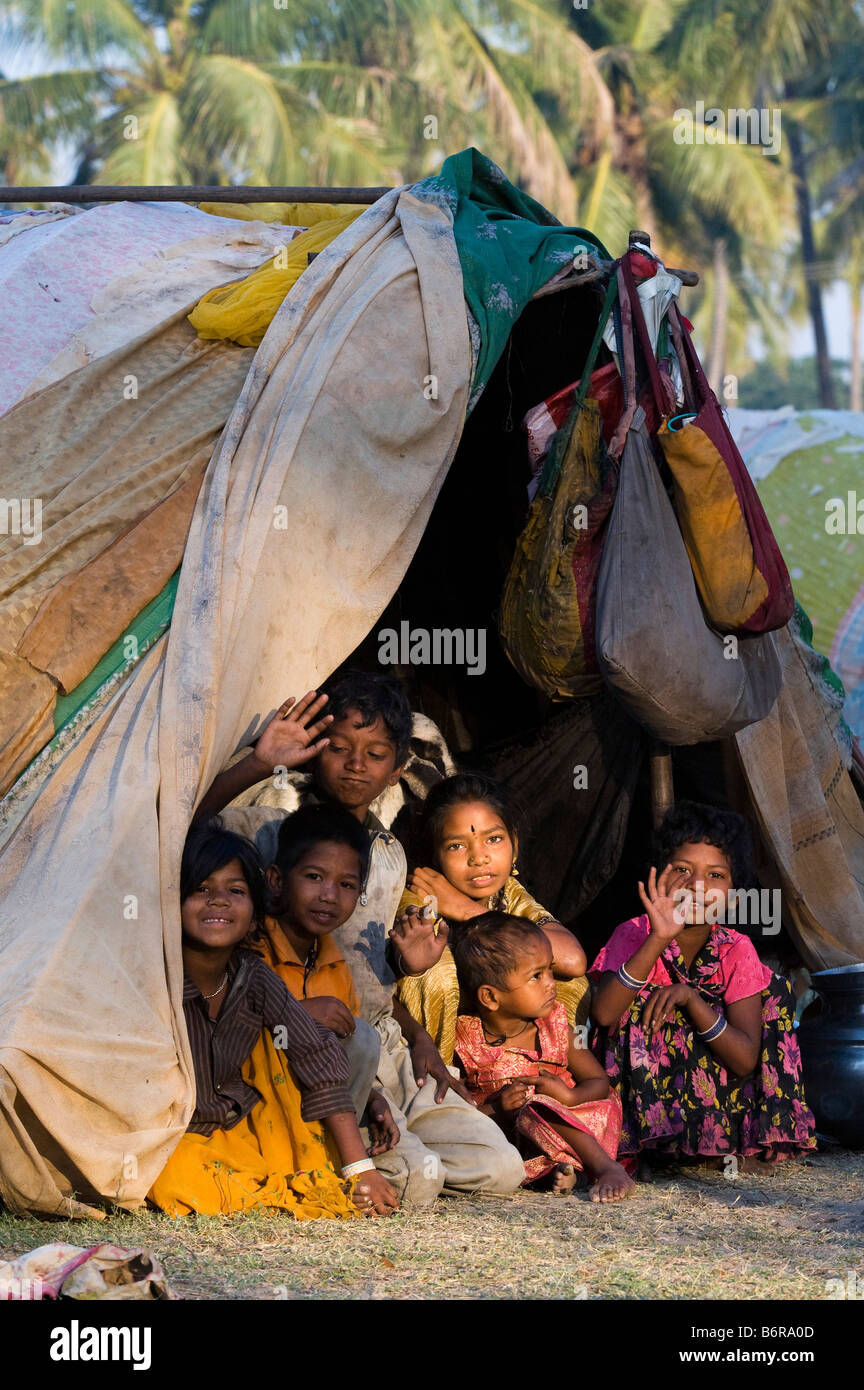 Povero indiano nomadi bambini, ragazzi e ragazze, seduti nella loro tenda al mattino presto la luce del sole. Andhra Pradesh, India Foto Stock