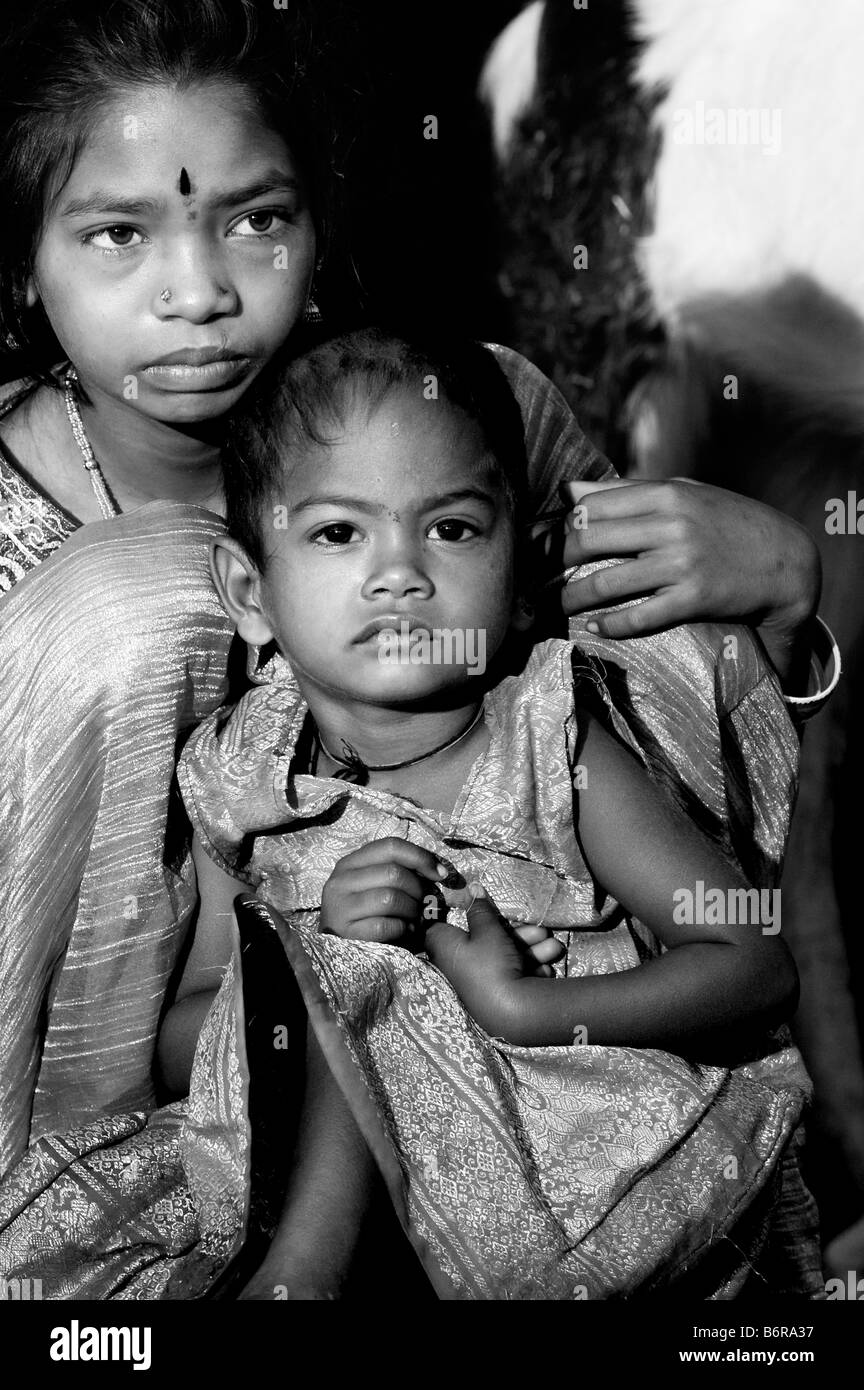 Poveri nomadi ragazza indiana e il suo bambino sorella. Andhra Pradesh, India. In bianco e nero Foto Stock