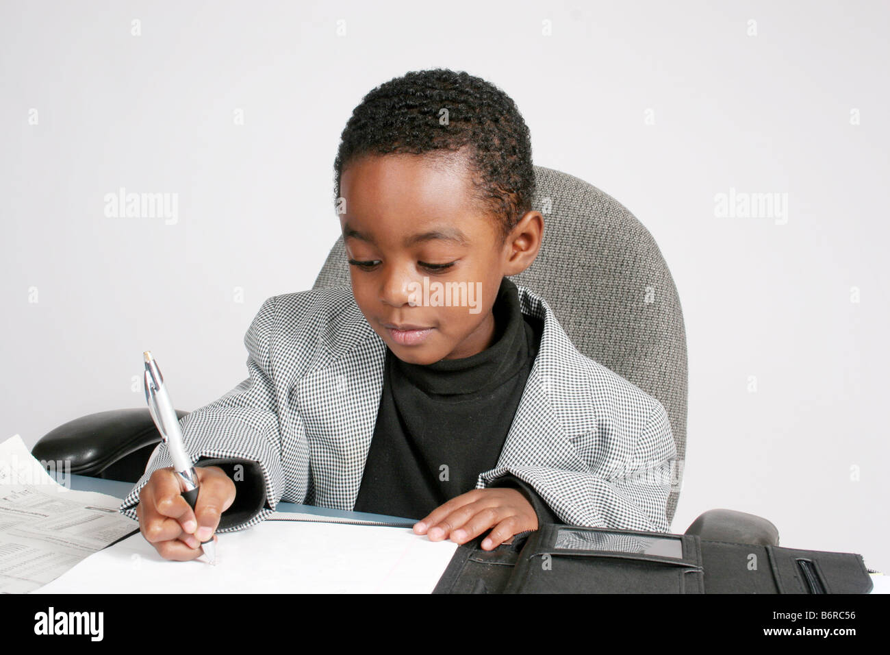 African American boy, vestito come un imprenditore iscritto su un foglio di carta Foto Stock