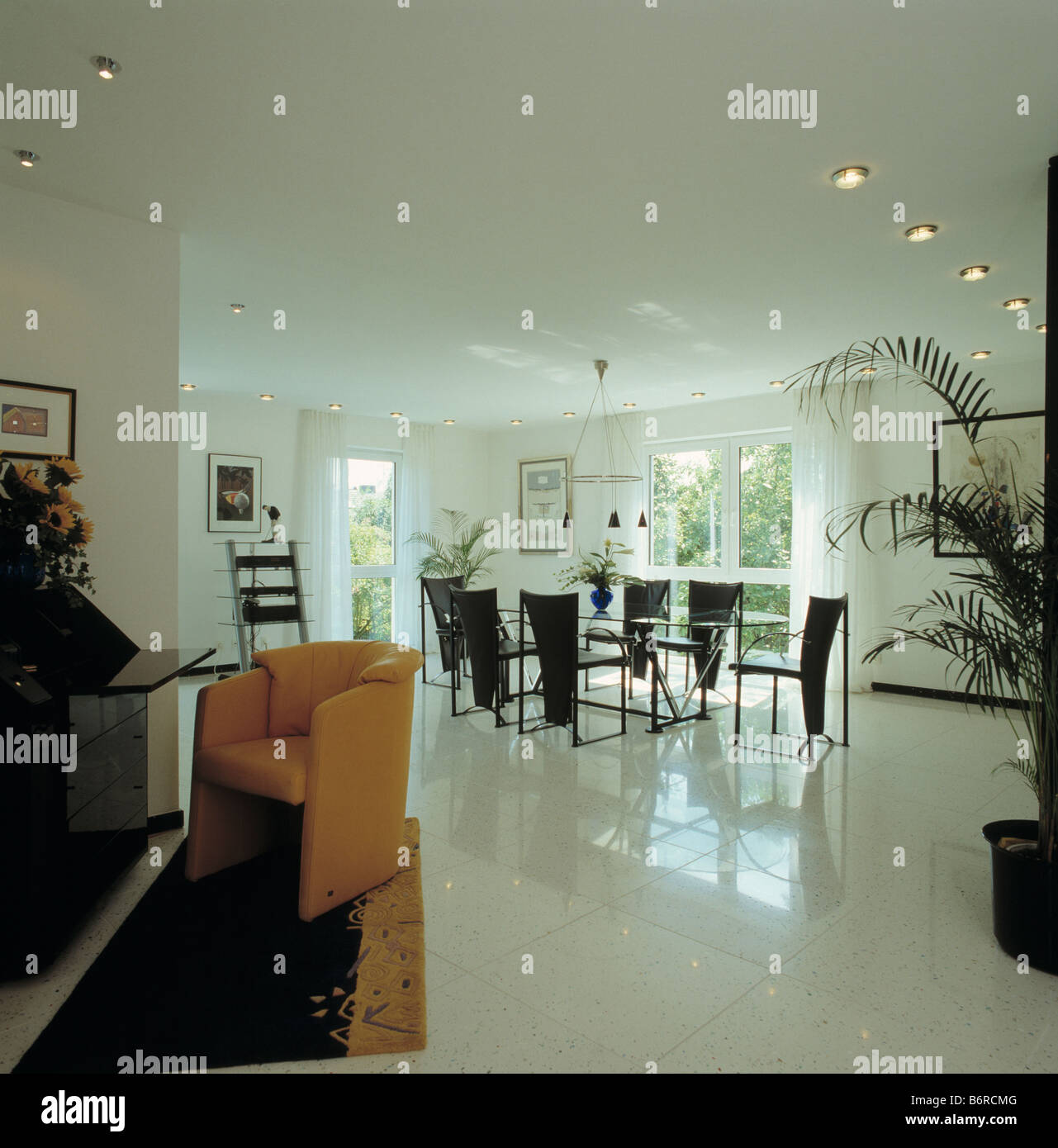 Bianco pavimento in ceramica in openplan moderna sala da pranzo nero con sedie e tavolo in vetro Foto Stock