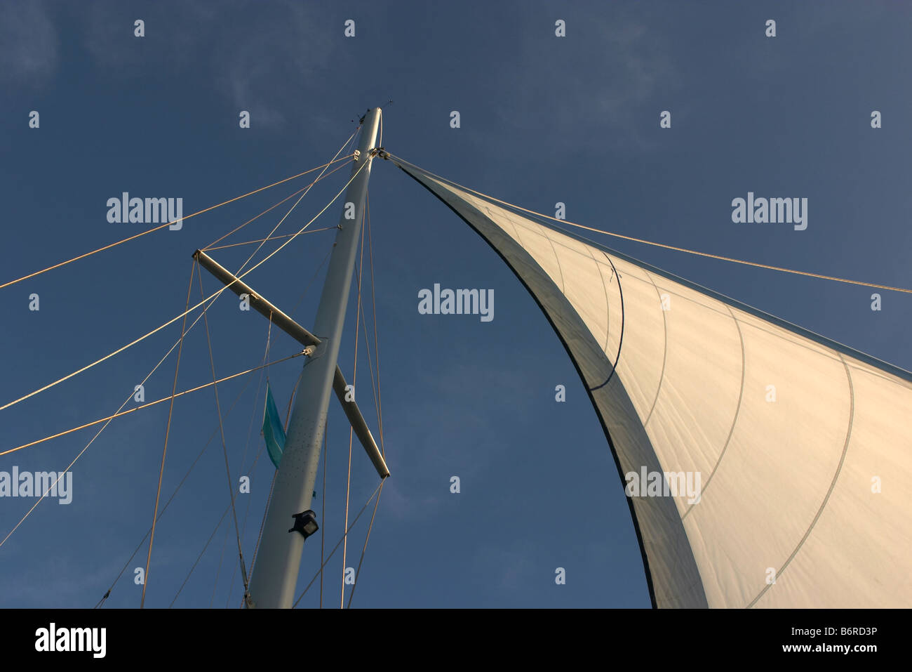 Montante di sollevamento e la crema bianca vela con armamento ed un cielo blu sullo sfondo Foto Stock