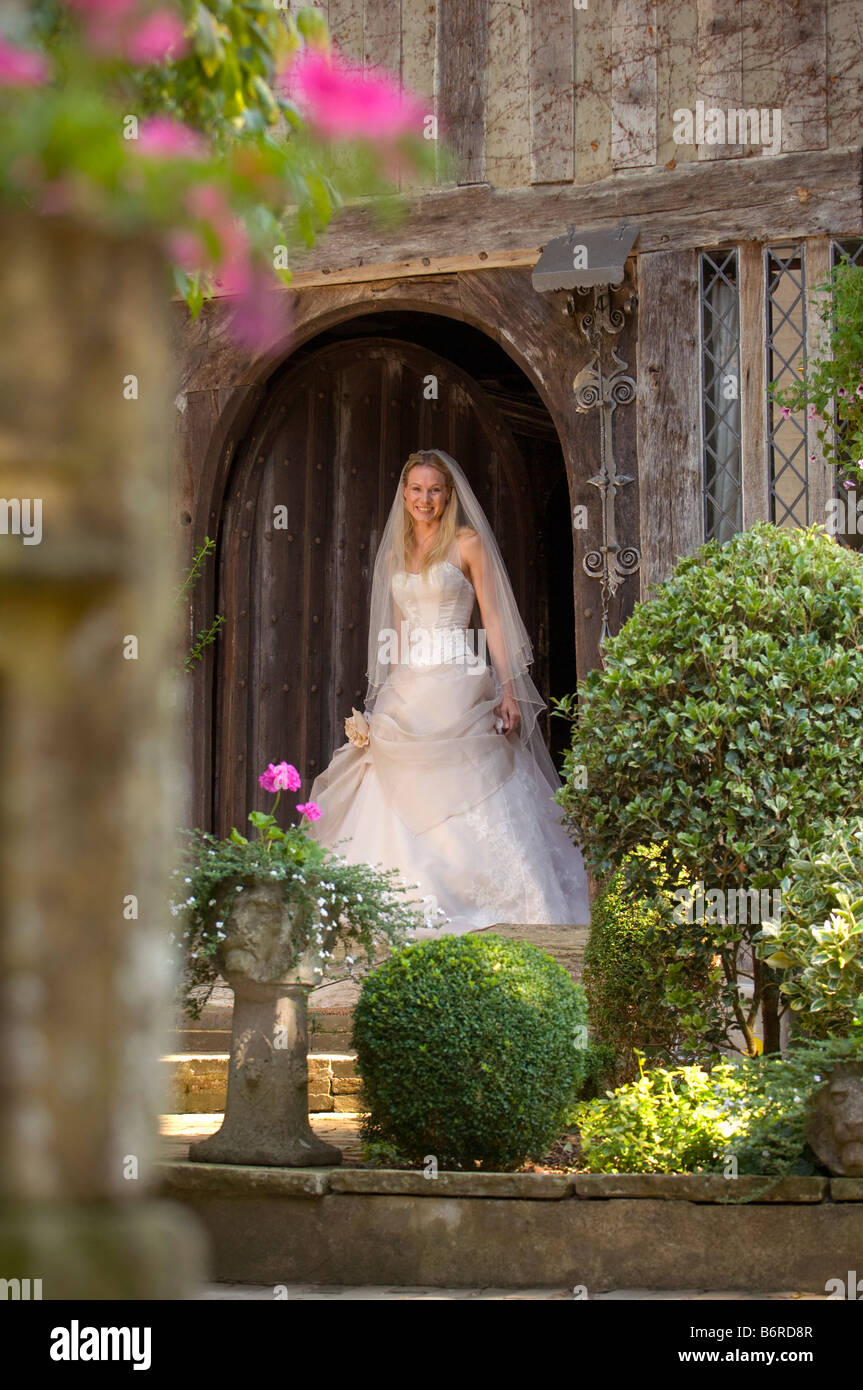 Un sorridente sposa esce dalla porta di casa di paese designer di indossare abiti da sposa da Becly Drinan. Foto da Jim Holden. Foto Stock