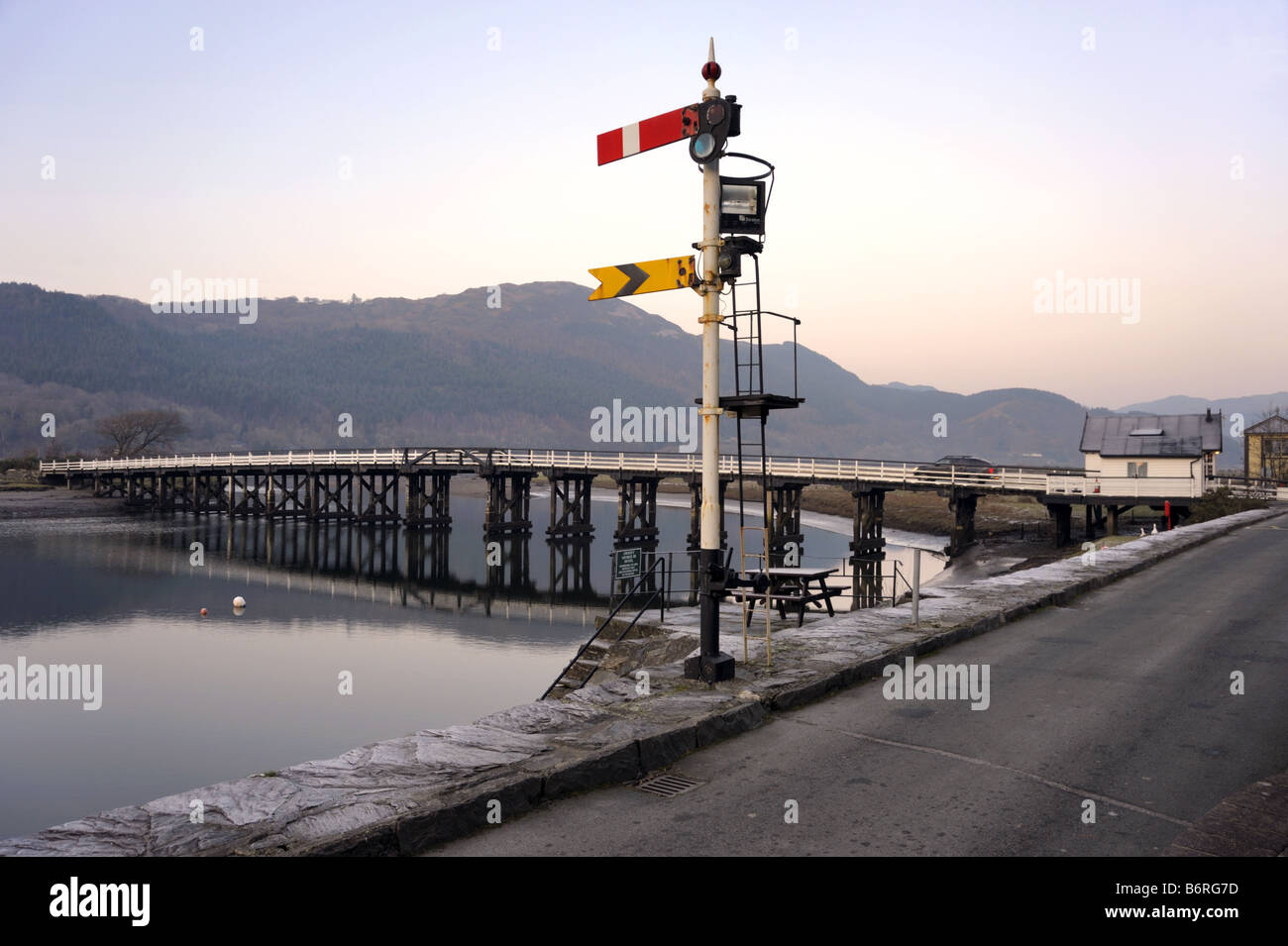Vecchia ferrovia sul segnale ferroviarie dismesse e la strada ponte a pedaggio, Penmaenpool, Mawddach Estuary, vicino a Dolgellau Galles Foto Stock