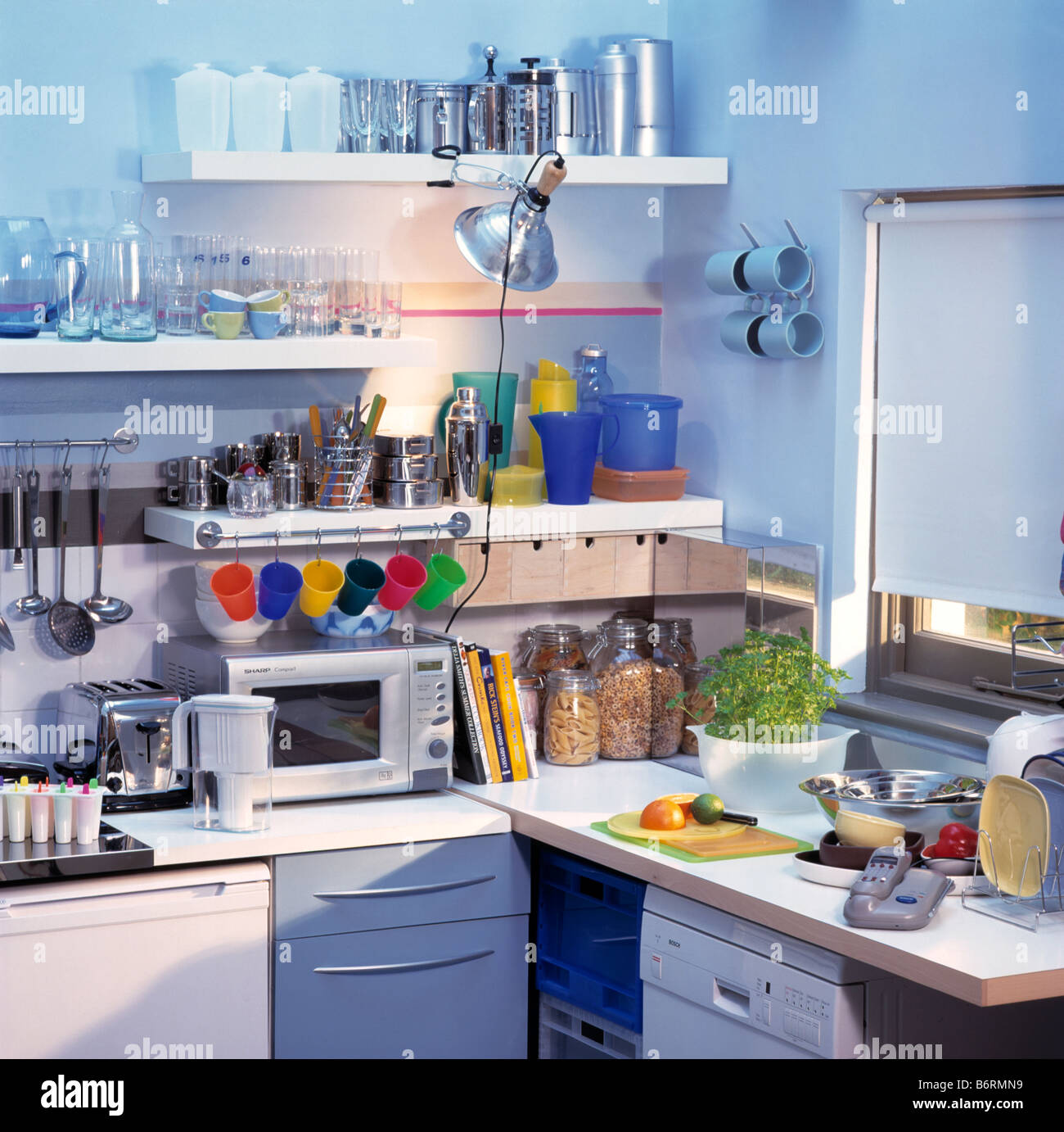 Fermaglio di metallo-luce sugli scaffali con vasi di deposito al di sopra  di un forno a microonde sul piano di lavoro di piccola economia cucina di  stile Foto stock - Alamy