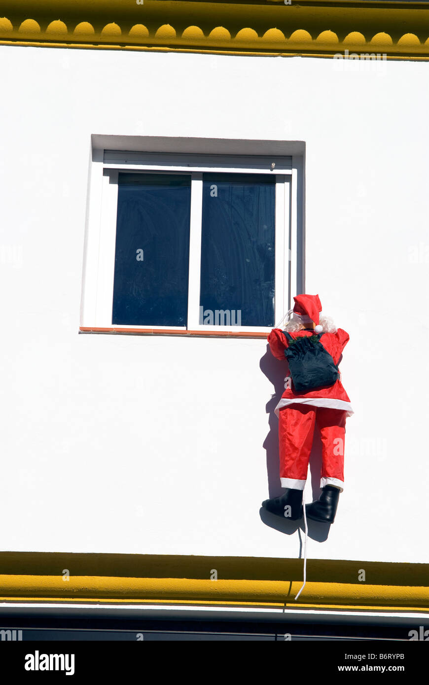 "Babbo Natale" scaling muro di casa per offrire presenta, Cadiar, Granada, Andalusia Spagna meridionale Foto Stock