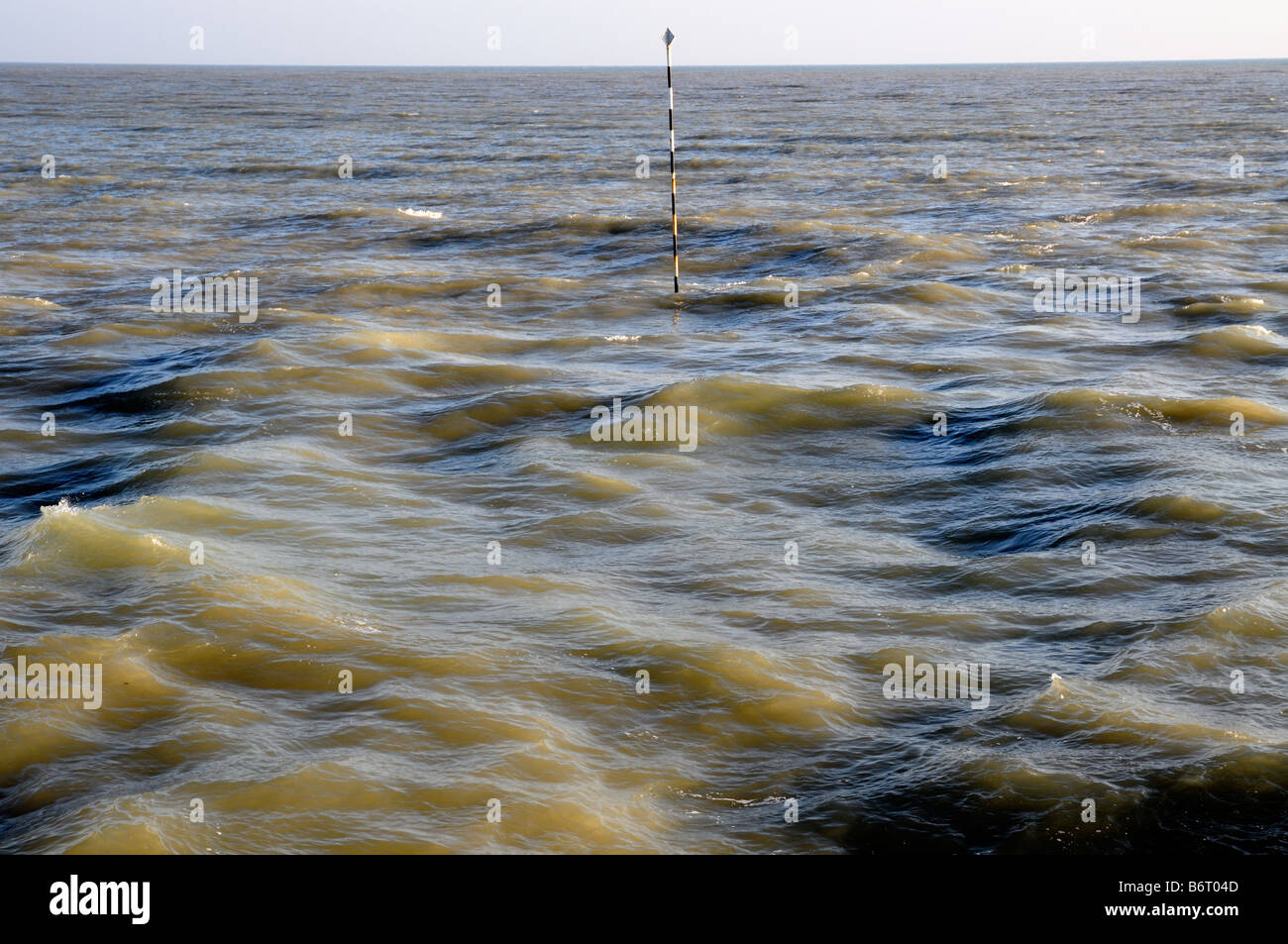 Un marcatore si erge nel mare a Littlehampton nel West Sussex, in Inghilterra. Foto Stock