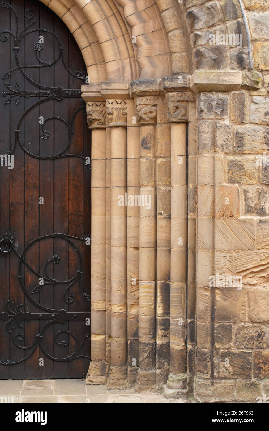 Impressionante grandi porte di legno con dettagliate arcata in pietra Foto Stock