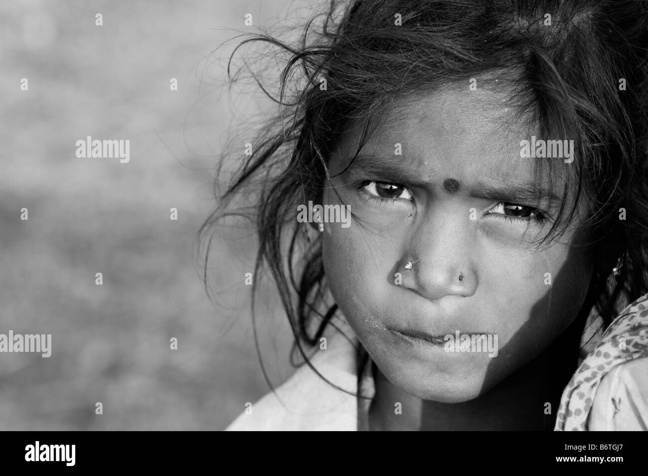 Poveri nomadi ragazza indiana staring ritratto. Andhra Pradesh. India. In bianco e nero. Messa a fuoco selettiva con copia spazio. Foto Stock