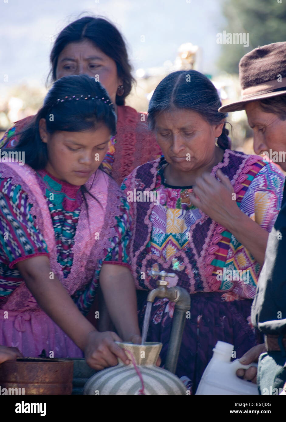 Le donne in abito tradizionale toccando l'acqua in un vaso sul cimitero di Quetzaltenango su 'Tutte le anime il giorno", Guatemala. Foto Stock