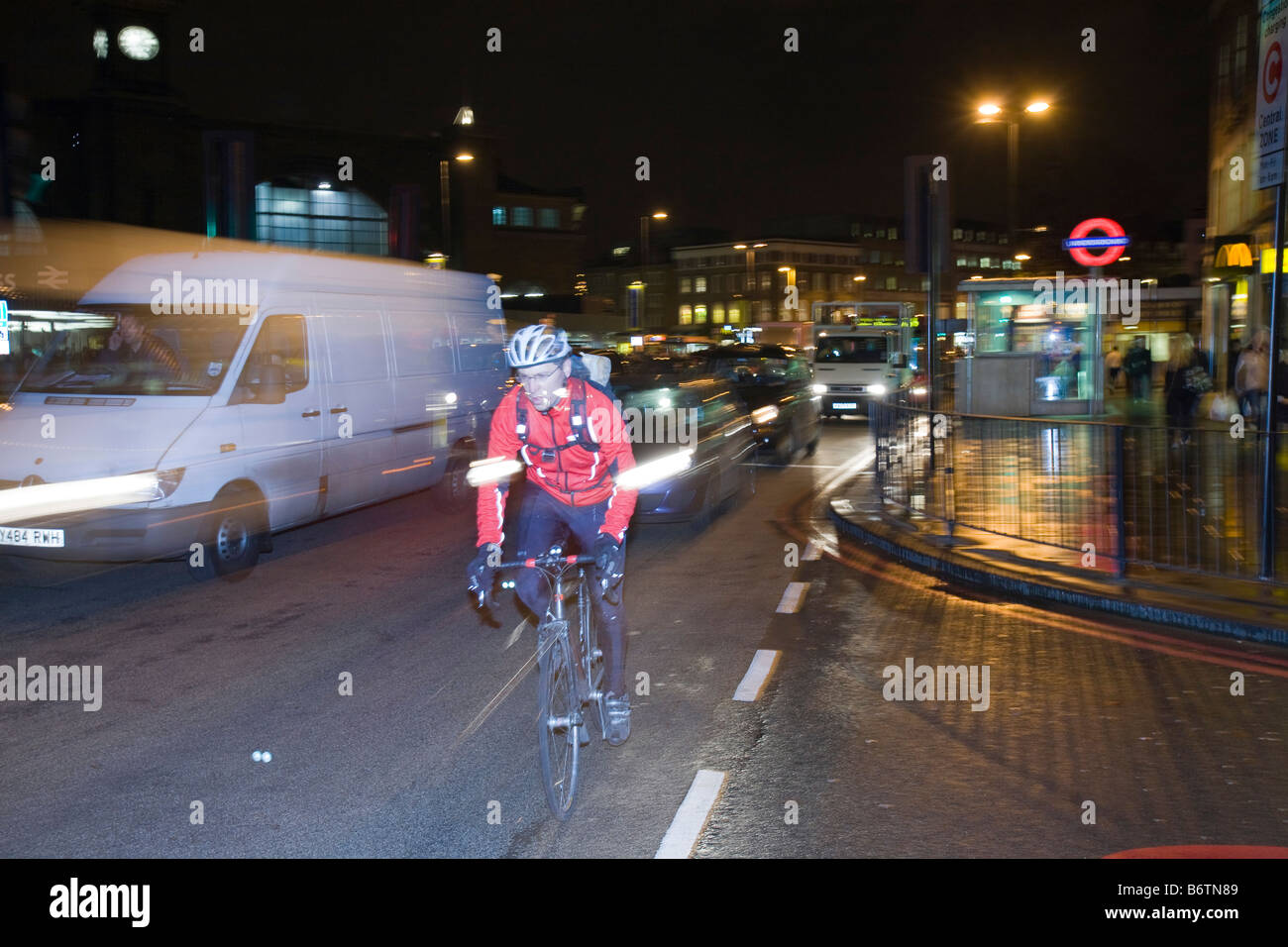 Un ciclista di notte al di fuori di Kings Cross London REGNO UNITO Foto Stock