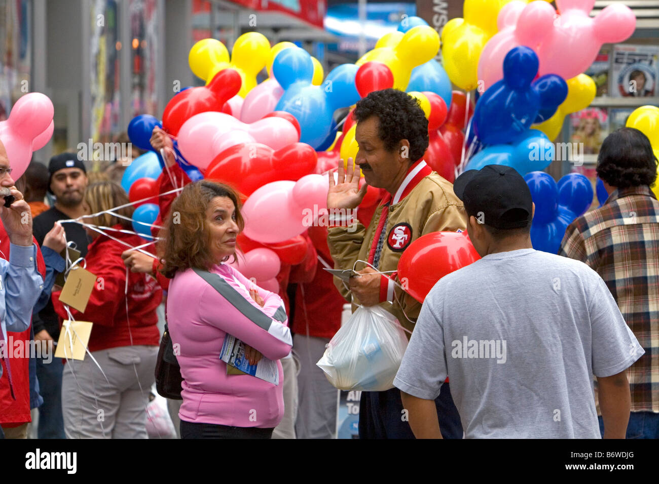 Promozionali palloncini Disney essendo distribuite in Times Square Manhattan New York City New York STATI UNITI D'AMERICA Foto Stock