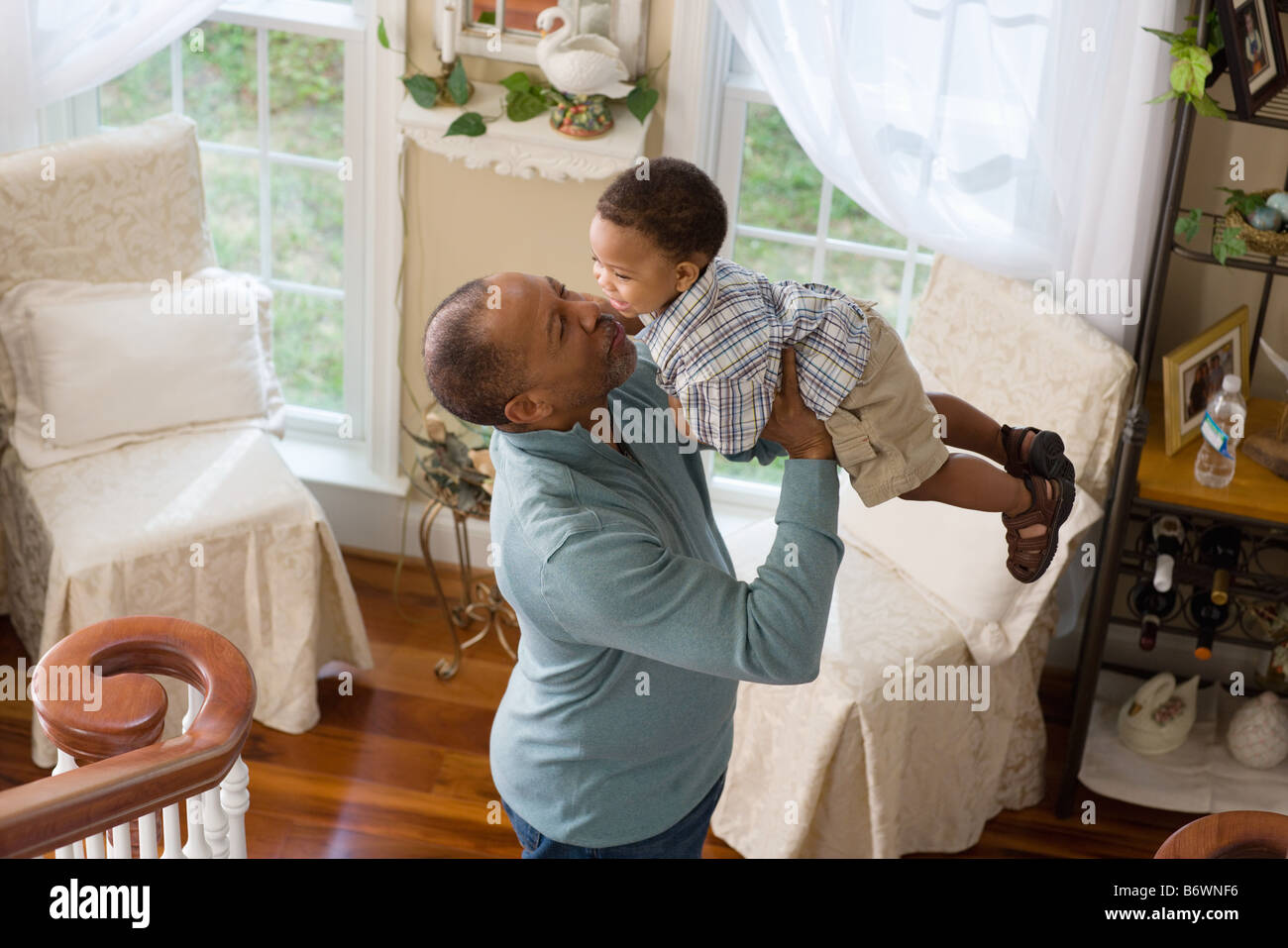 Un nonno sollevando il nipote in aria Foto Stock