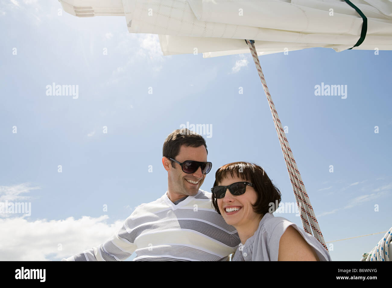 Coppia sorridente su una barca a vela Foto Stock