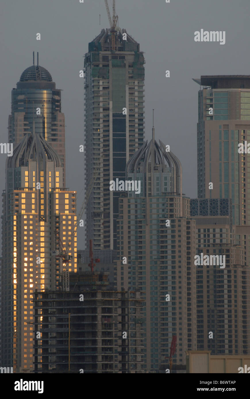 I grattacieli di Dubai glinting sunrise su windows alcuni in costruzione Foto Stock