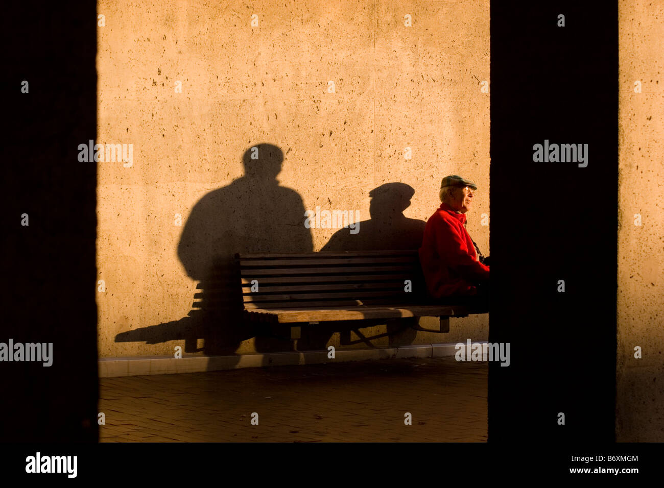 Un vecchio uomo che parla ad una persona invisibili Foto Stock