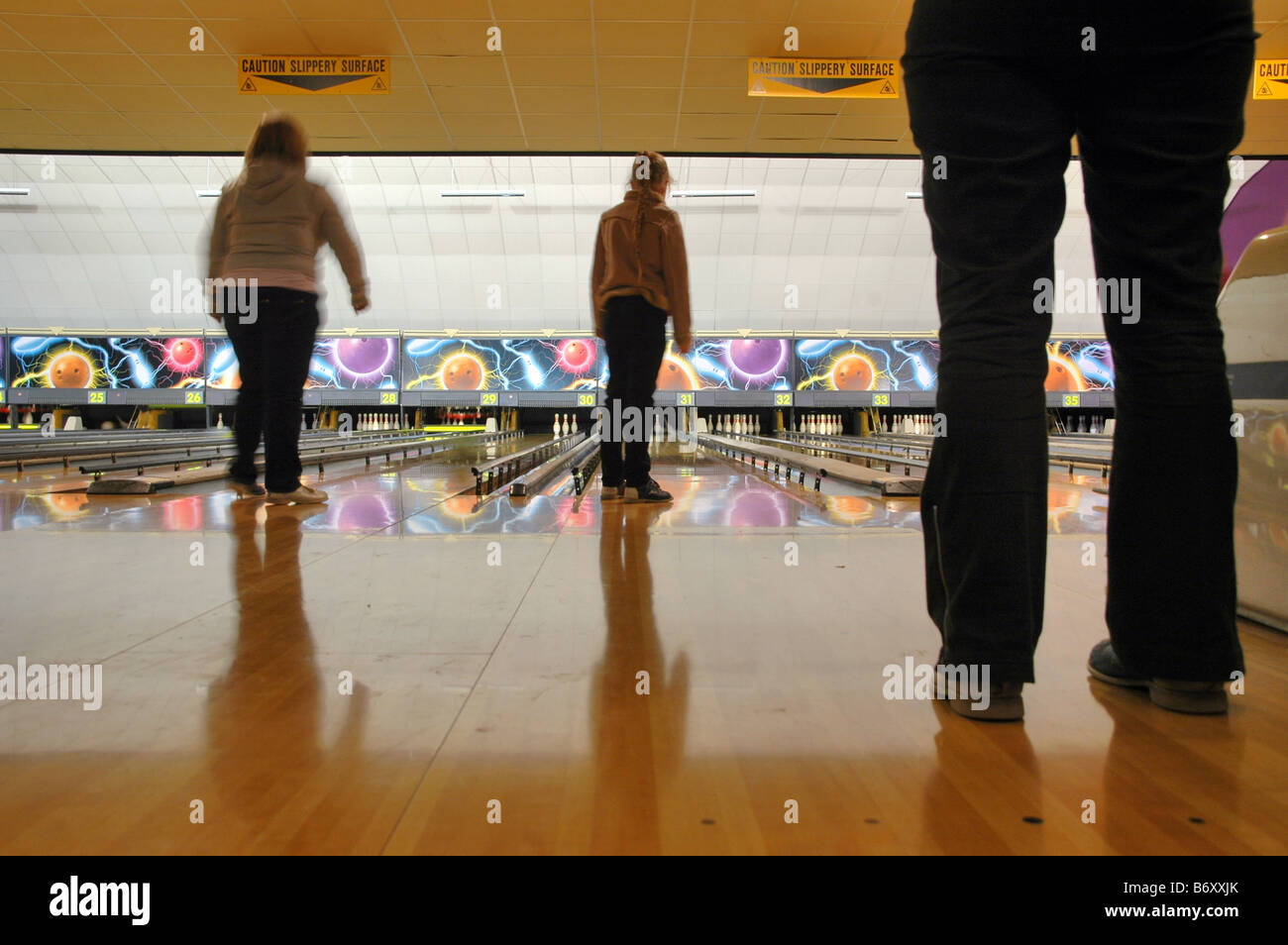 Giocatori e uno spettatore a dieci pin bowling. Foto Stock