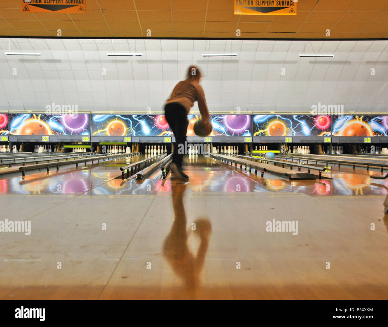Una giovane ragazza riproduce ten pin bowling. Foto Stock