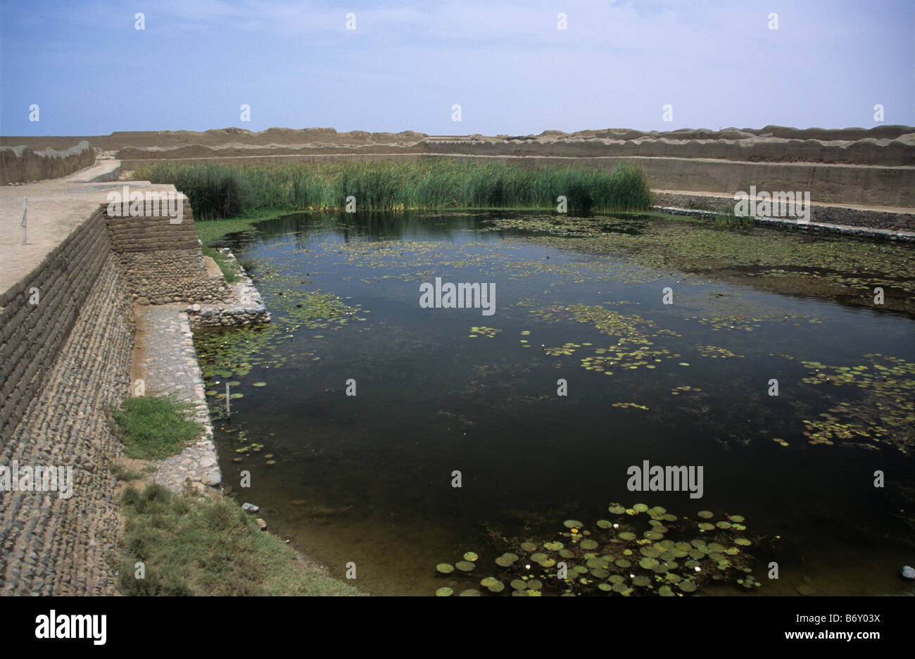 Il lago per deposito di acqua e adobe (mattone di fango) di parete, Chan Chan, vicino a Trujillo, Perú Foto Stock