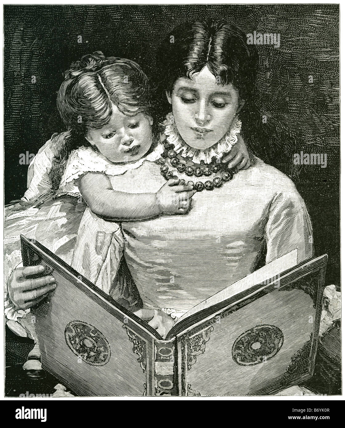 Madre la lettura del libro di apprendimento del bambino seduto sul giro storia del ginocchio abbigliamento tradizionale letto tempo Ragazza donna figlia Foto Stock