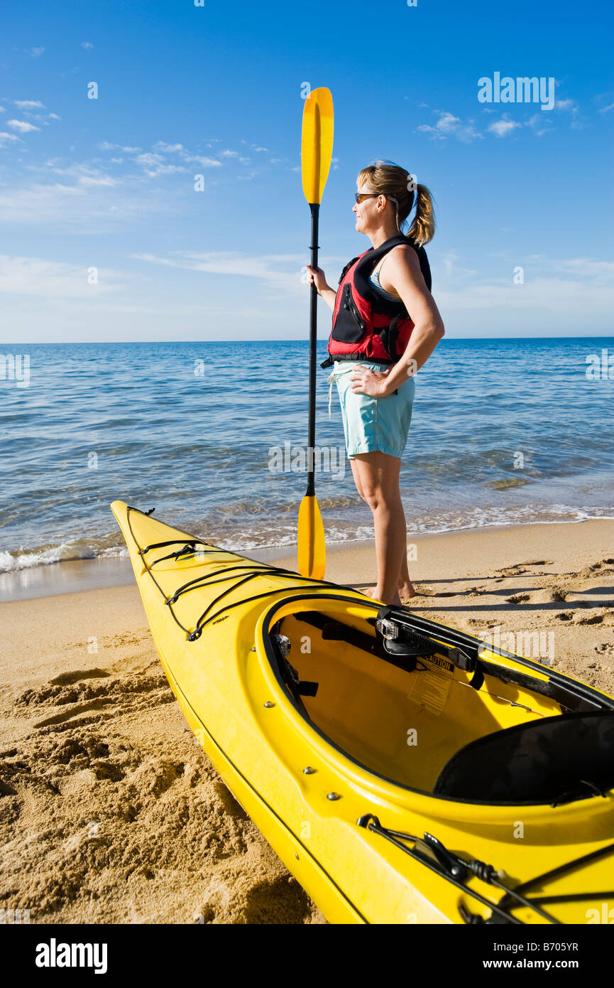 Una donna che guarda al mare con il suo kayak di mare sulla spiaggia, Kino Bay, Messico. Foto Stock