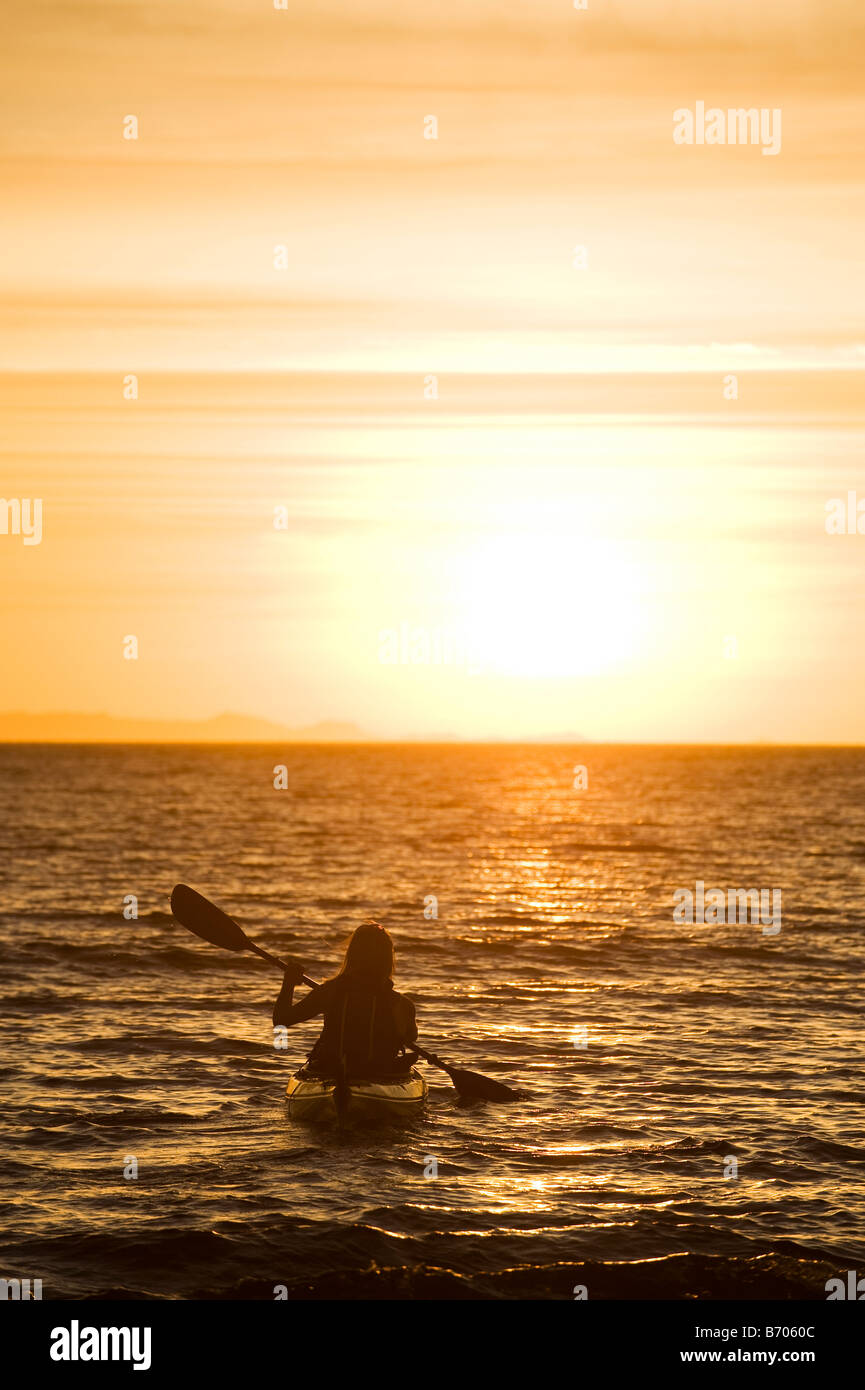Una donna kayak di mare nel tramonto in Kino Bay, Messico. Foto Stock