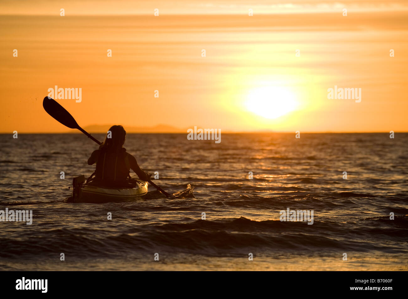 Una donna kayak di mare nel tramonto in Kino Bay, Messico. Foto Stock
