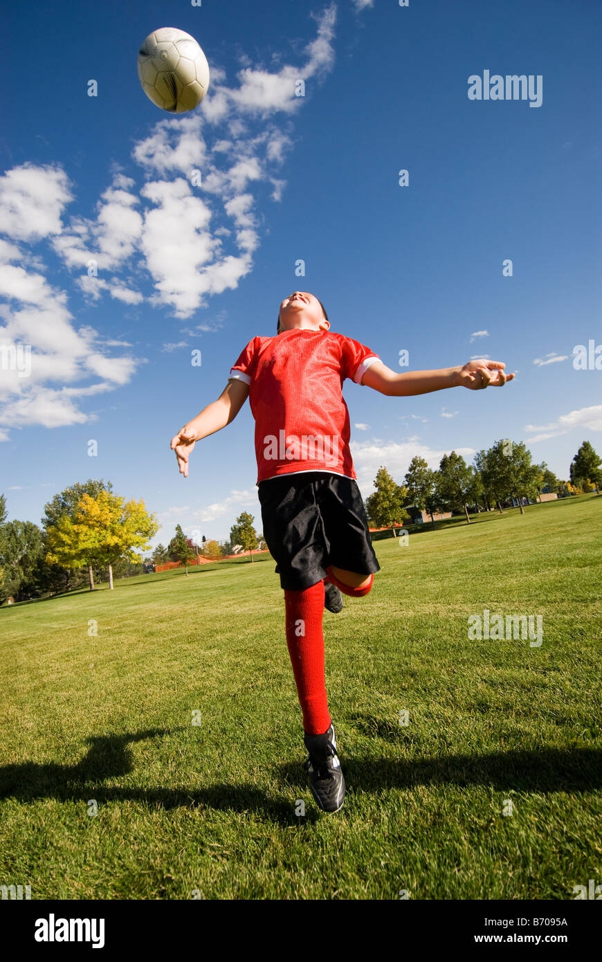 Un ragazzo fa una testata con il pallone da calcio in Fort Collins, Colorado. Foto Stock