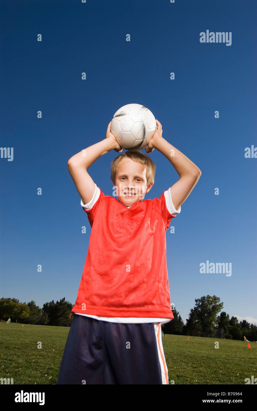 Un ragazzo si prepara a lanciare la palla calcio in Fort Collins, Colorado. Foto Stock