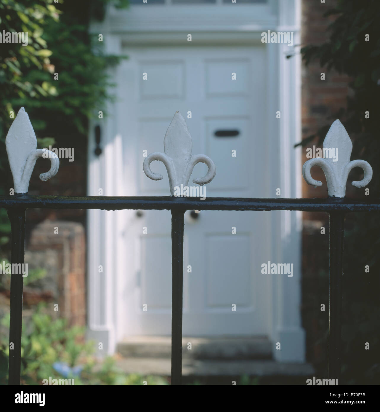 Close-up di bianco Fleur de Lis su Victorian ringhiere in ferro battuto nella parte anteriore del bianco dello sportello anteriore Foto Stock