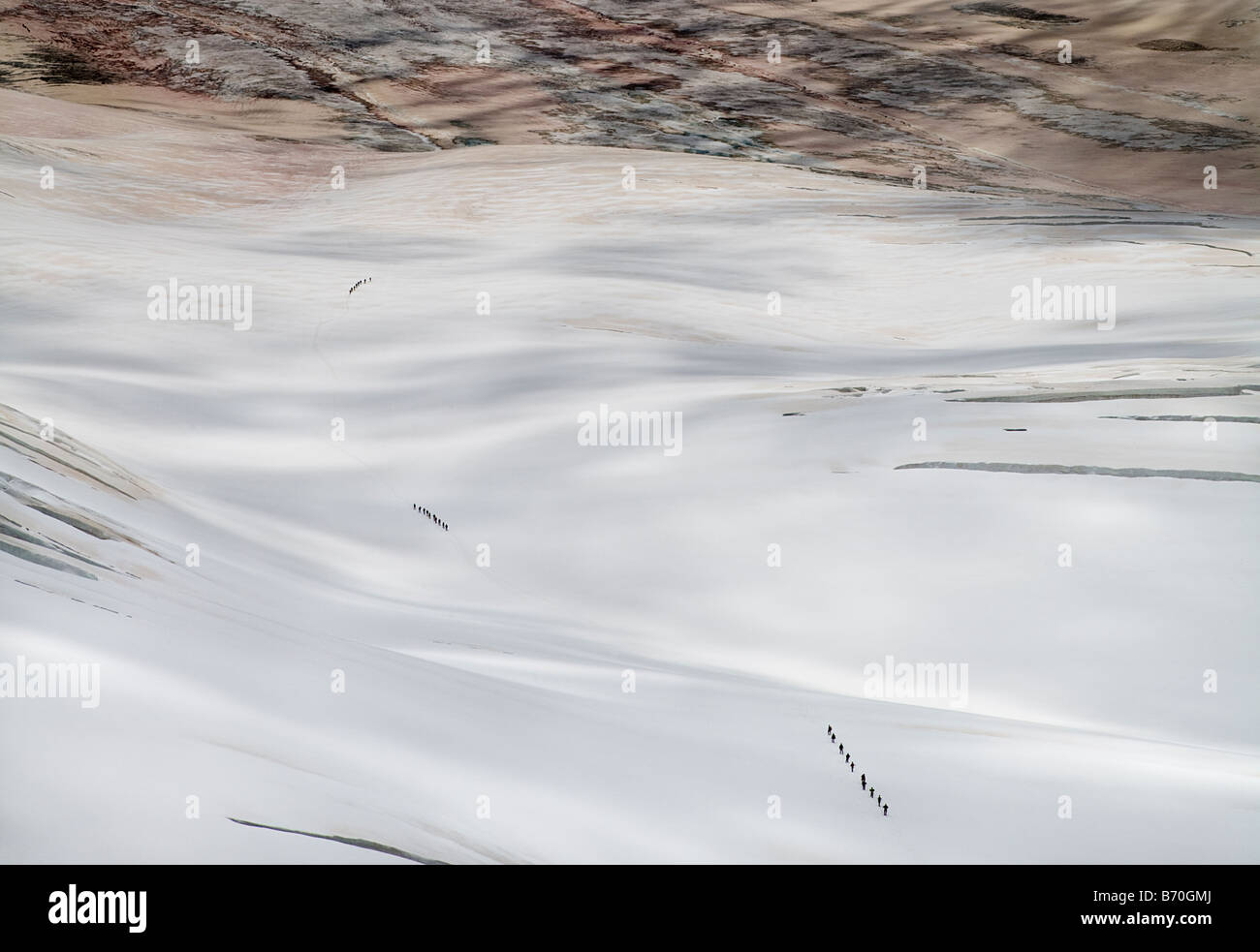 Tre parti del ghiacciaio walkers sul Aletschgletscher, Alpi Svizzere. Il colore marrone è polvere soffiata dal deserto del Sahara Foto Stock