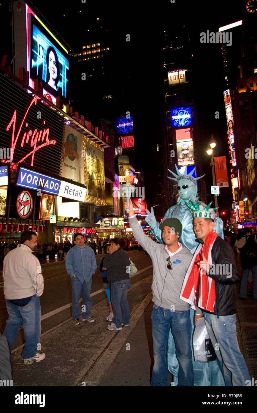 I turisti in Times Square di notte a Manhattan New York City New York STATI UNITI D'AMERICA Foto Stock