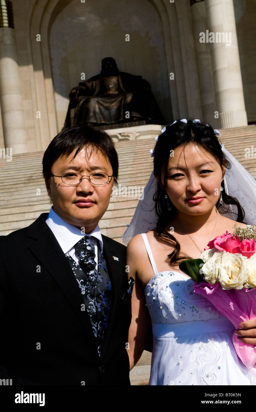 Sposi novelli pongono di fronte al Chingis Khan statua, la casa del parlamento, Piazza Sukhbataar, Ulan batarr Foto Stock