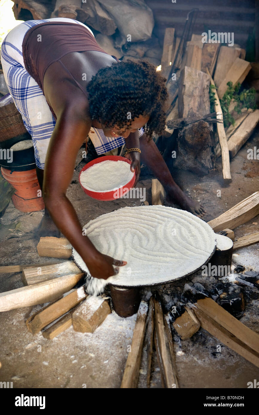 Il Suriname, Laduani, presso la banca di Boven Suriname fiume. Una donna dalla tribù Saramaccaner la cottura del pane di manioca o cassava Foto Stock
